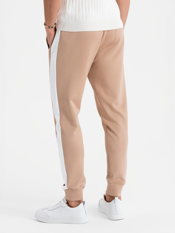 Męskie dresowe spodnie joggery z kontrastowymi lampasami – beżowe V4 OM-PASK-0229