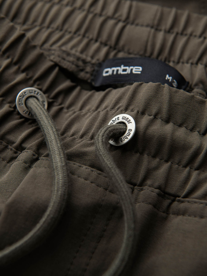 Męskie spodnie joggery z kieszeniami cargo i printem – ciemnooliwkowe V5 OM-PAJO-0200